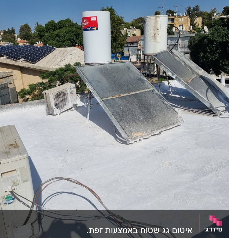 גג אטום בלבן עם קולטי שמש ומזגנים